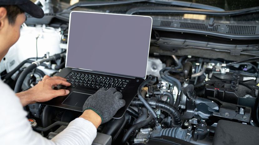 Mechanical engineer use computer check and programming to tune car after repair in the service shop