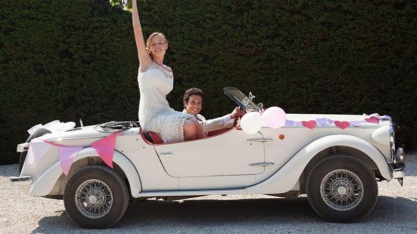 Newlyweds leaving for honeymoon in vintage car