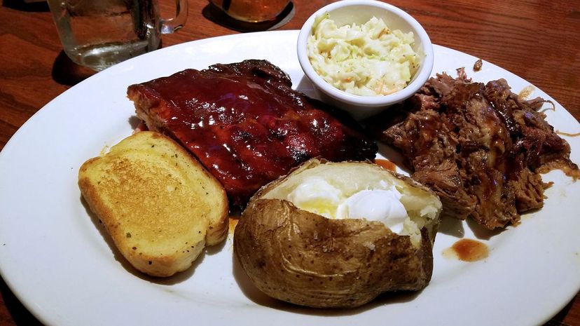 Barbeque baby back ribs with brisket, baked potato, and Cole slaw