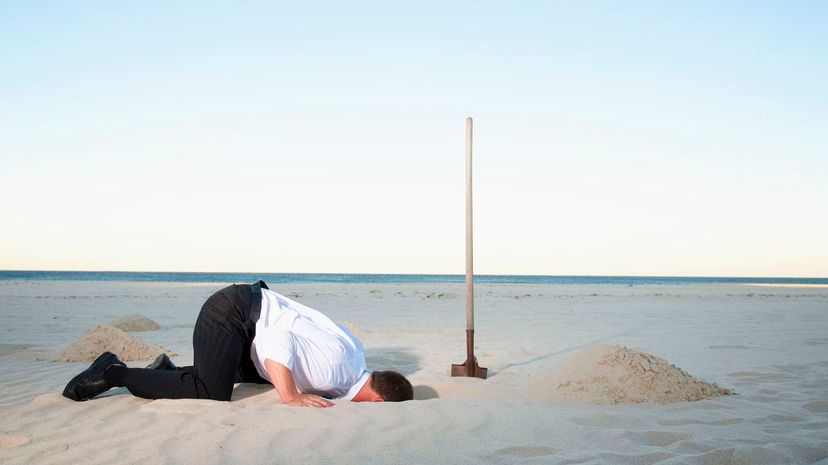 Man burying head in sand