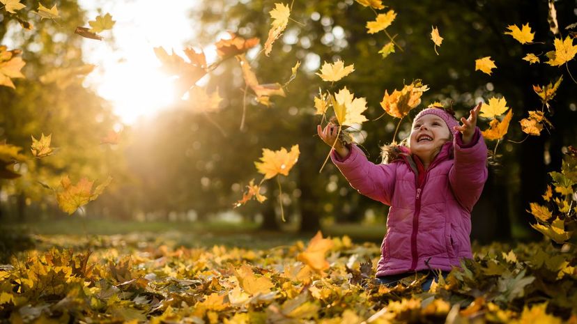 Playful Girl Throwing Leaves