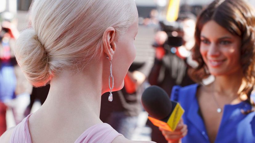 Celebrity speaking to reporter on red carpet