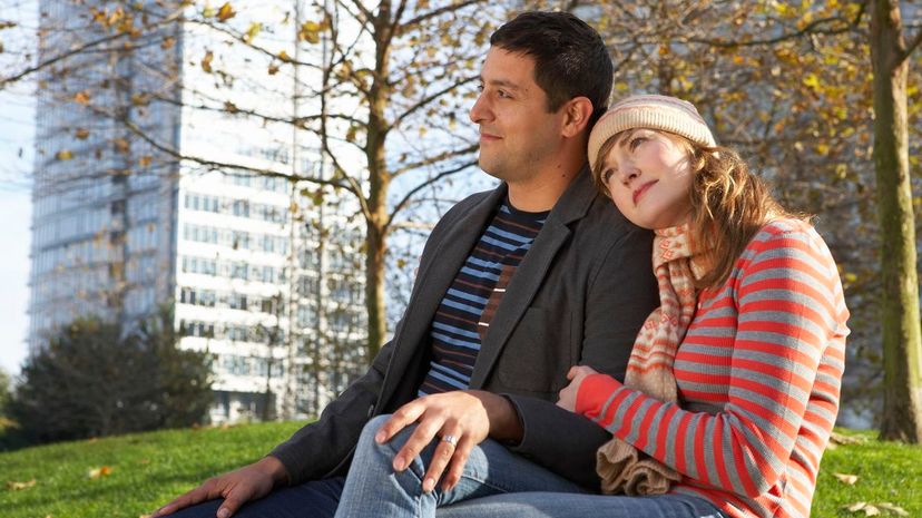 Couple sitting in urban park embracing