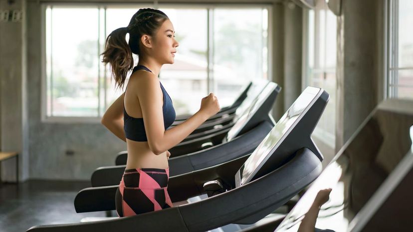 Young women running on treadmill at gym
