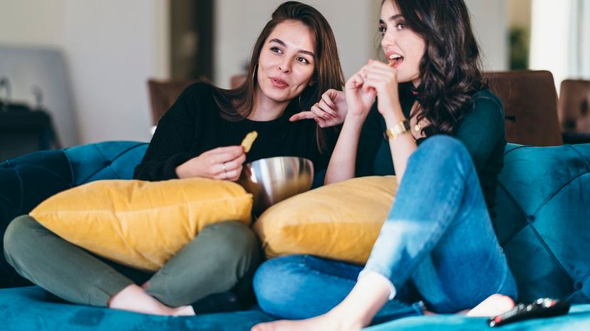 Female friends eating chips and watching tv
