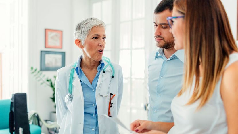 Young couple talking to doctor