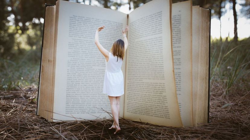 Magic big book standing young woman in forest