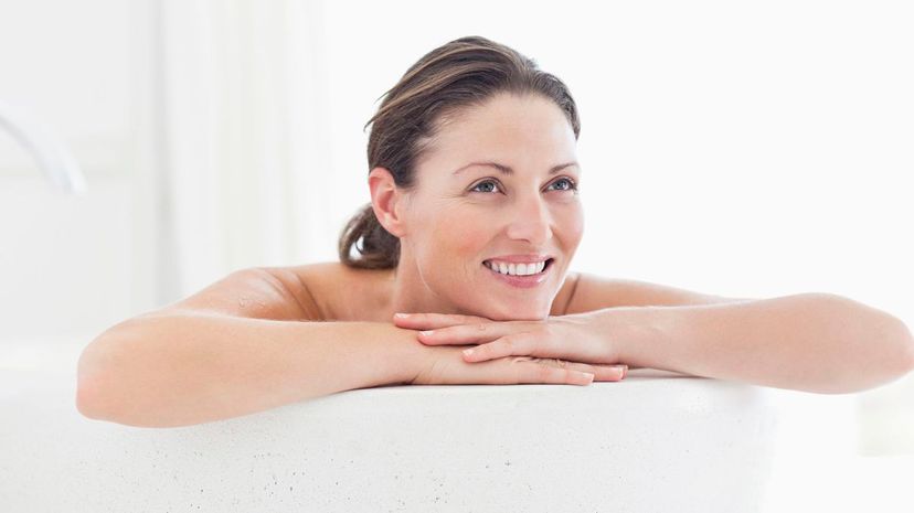 Mid adult woman smiling in bathtub