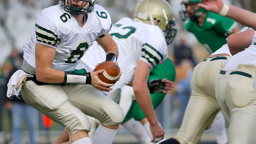 A american high school football quarterback turns to handoff the ball