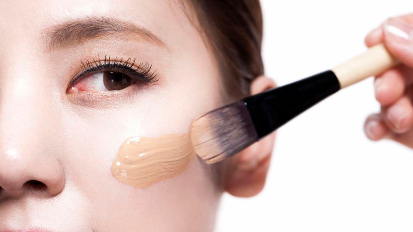 Woman applying foundation with make-up brush