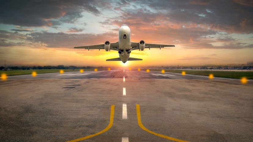 Airplane taking off from the airport runway in beautiful sunset light