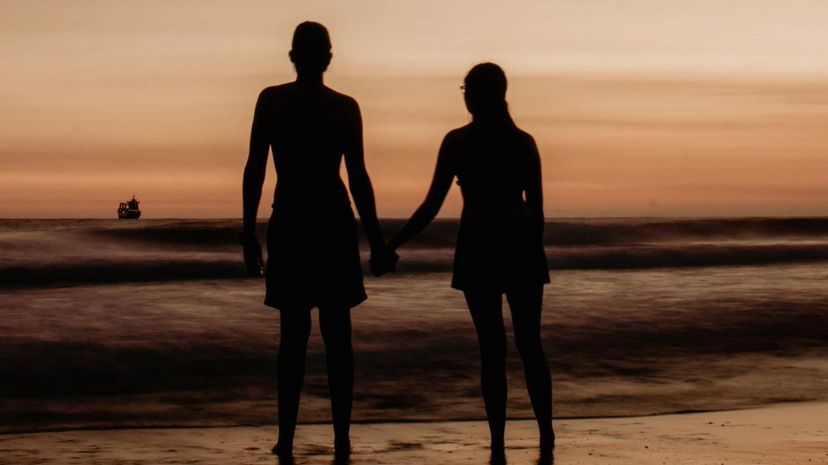Couple hold hands beach