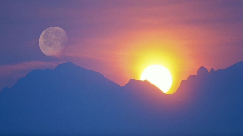 Sun and moon behind mountain