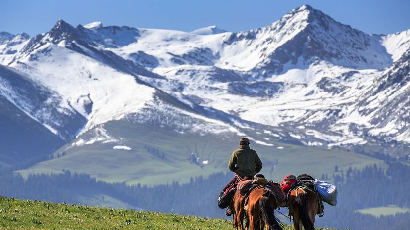 A Kazakh man riding horse on Kalajun grassland in Tian Shan mountains