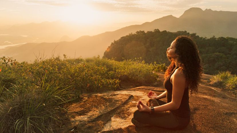 Woman meditating on mountain