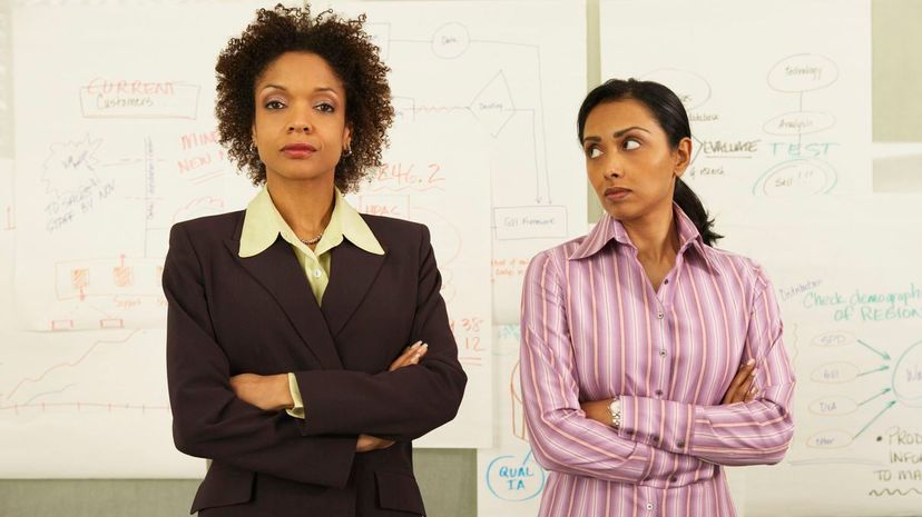 Two unhappy businesswomen standing together