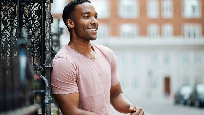 Enigmatic / handsome black man pink shirt in city