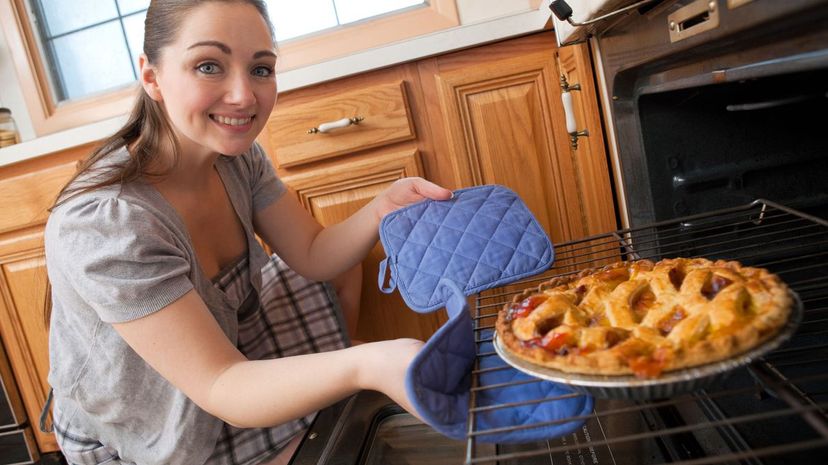 Woman pulling a pie from the oven