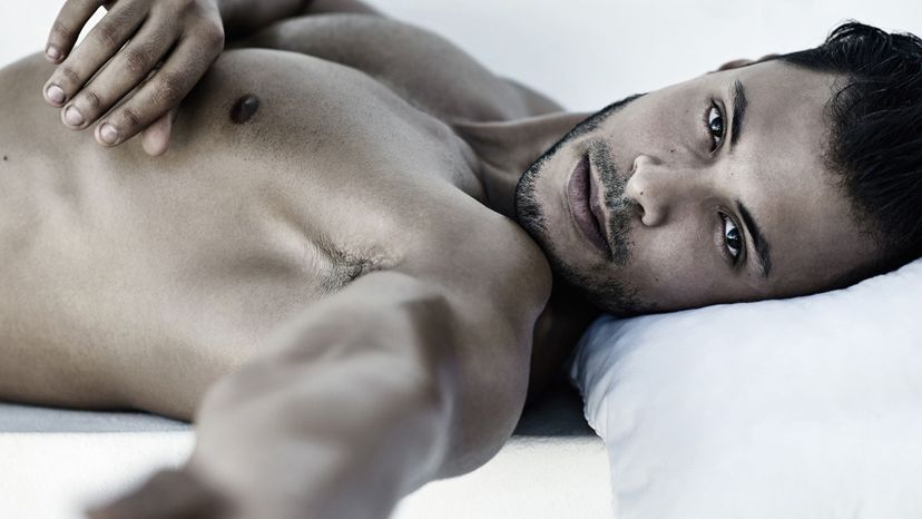 attractive man in bed come hither look dark hair scruffy 