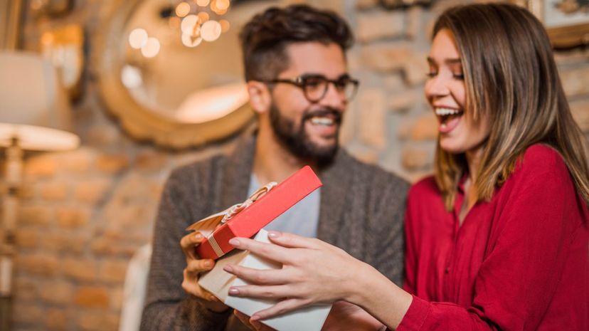 Cheerful young woman receiving a gift from her boyfriend