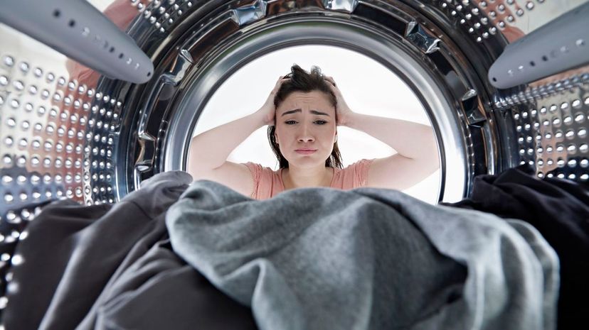 Unhappy woman looking from inside a washing machine