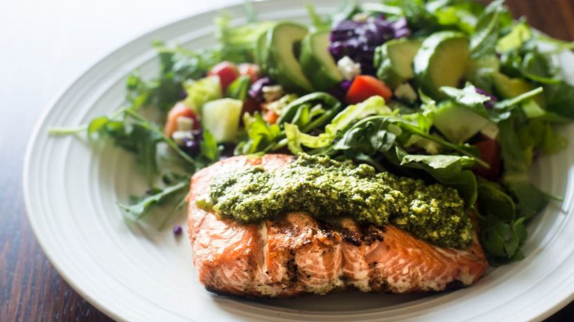 Salmon fillet topped with arugula pesto and salad