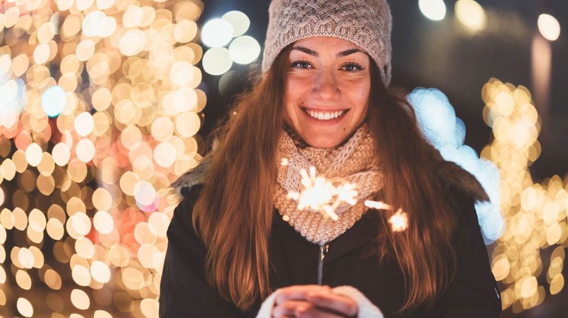 Happy woman holding burning sparkler