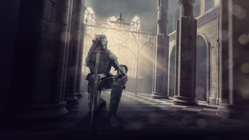 Medieval Knight in Armour Kneeling With Sword Inside Castle