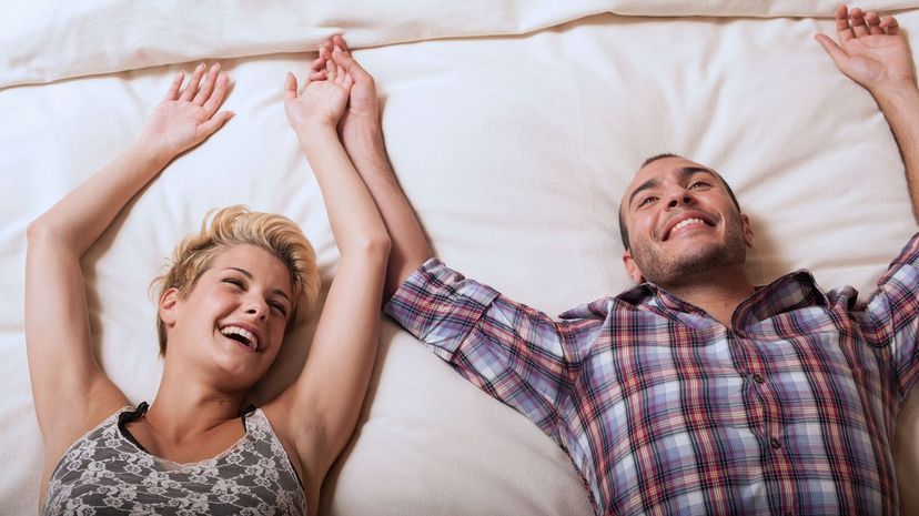 Couple relaxing on hotel room bed