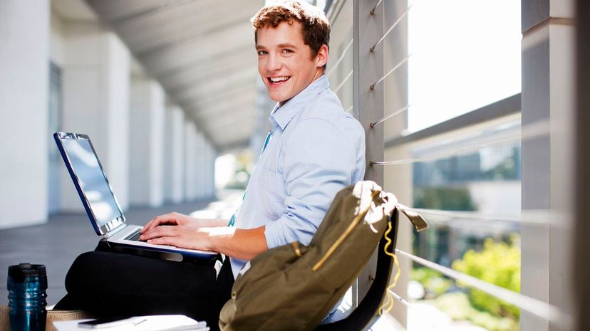 Student working on laptop on floor