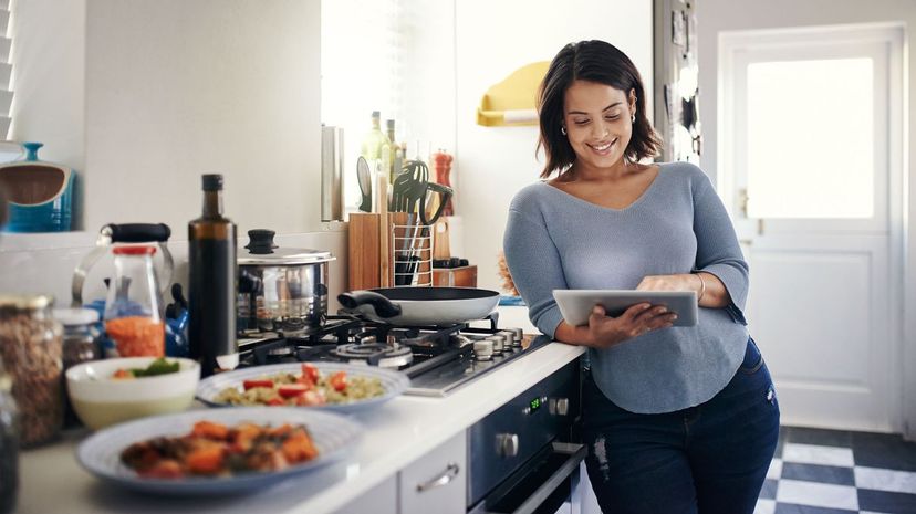 Woman using a digital tablet while cooking at home