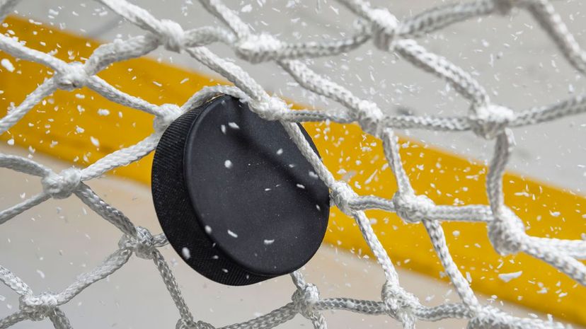 Close-up of an Ice Hockey puck hitting the back of the net