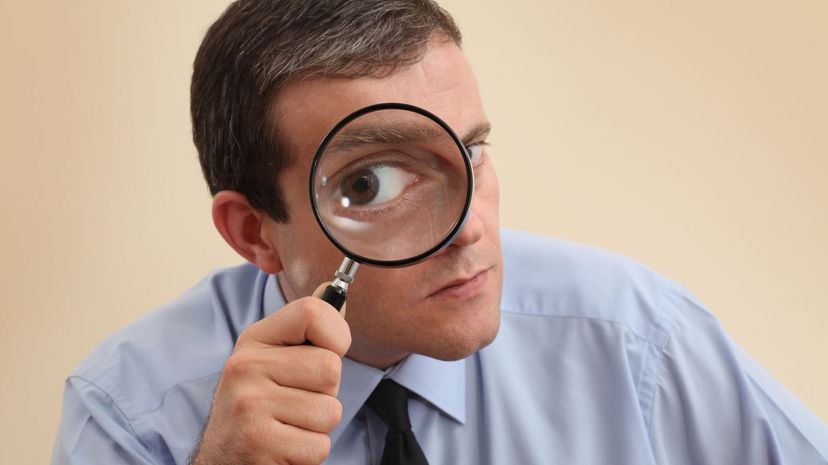 Businessman looking through magnifying glass