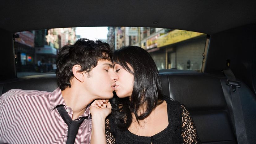Couple kiss in the back of a car