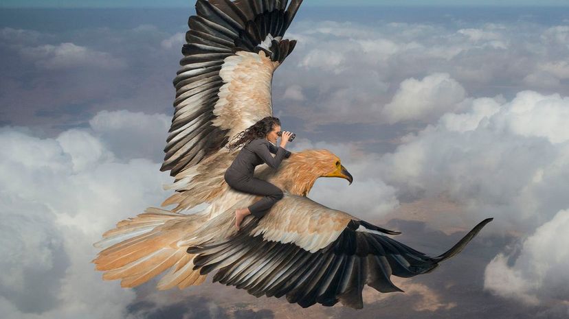 Woman riding eagle flying over clouds in sky