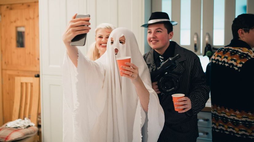 Person Dressed Up as Ghost with Phone