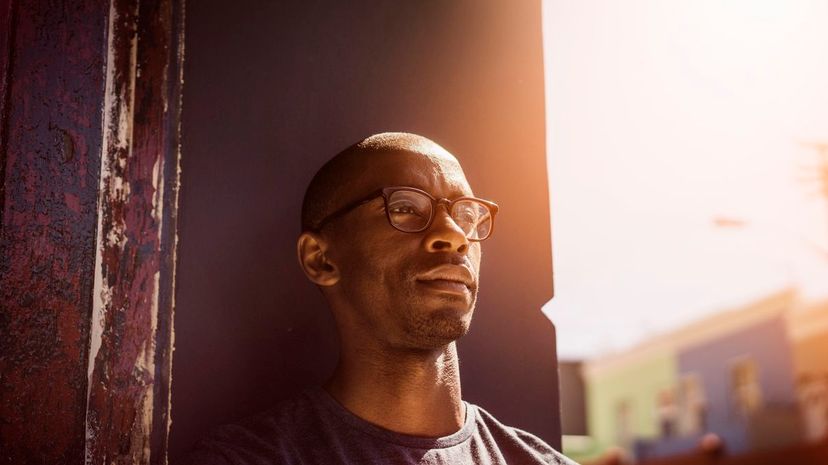 Thoughtful man leaning on wall in city