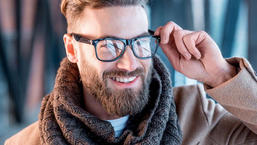 handsome man beard holding glasses brown scarf