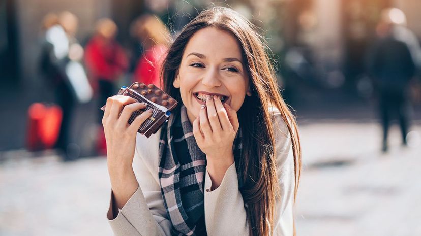 Woman eating chocolate feeling a bit guilty