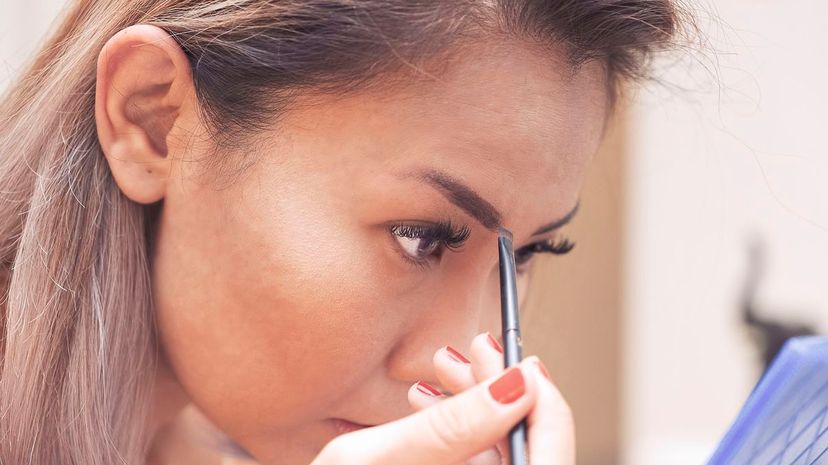 Woman drawing her eyebrows