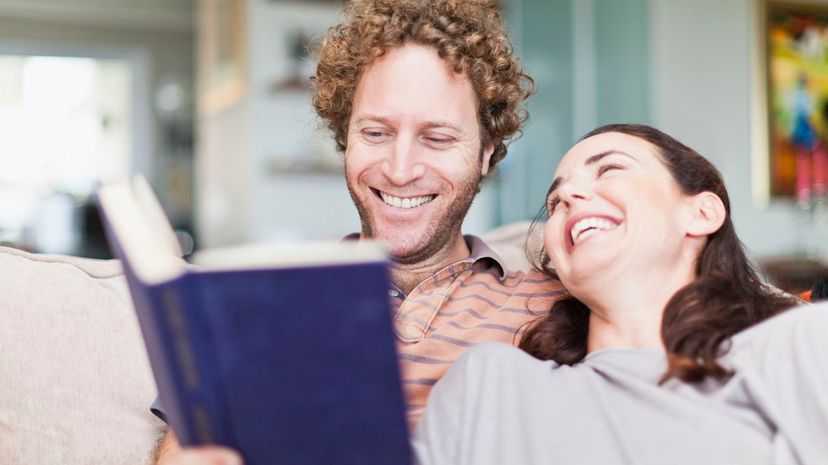 Couple laughing at book