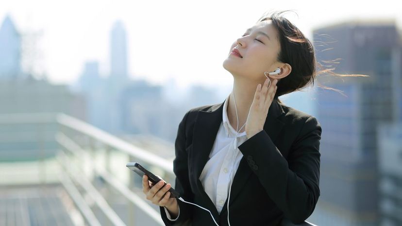 Businesswoman listening to music