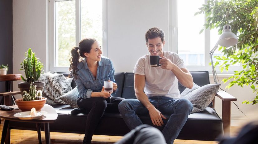 Couple having coffee together in living room