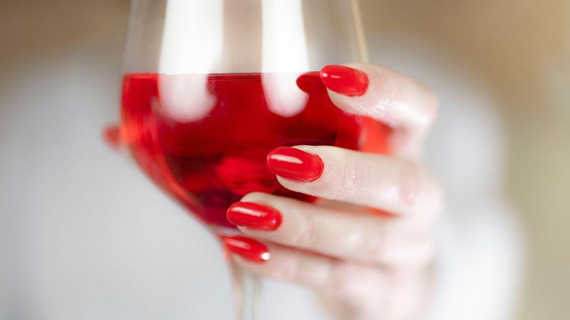 Woman's hand holding glass of red wine