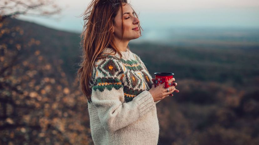 Woman in sweater holding a cup