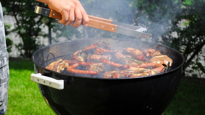 Cuatro grandes trozos de carne en un asador cocinar sobre un fuego