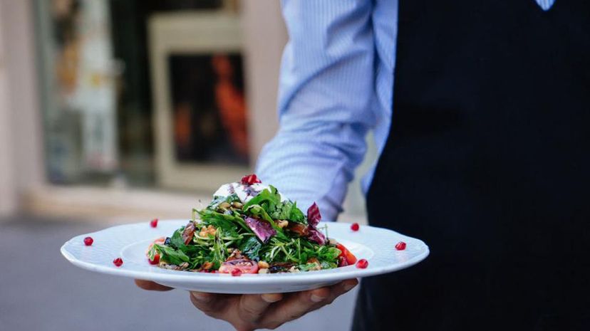 Waiter bringing salad