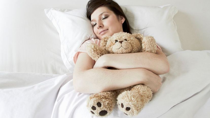 Woman in bed with teddy bear