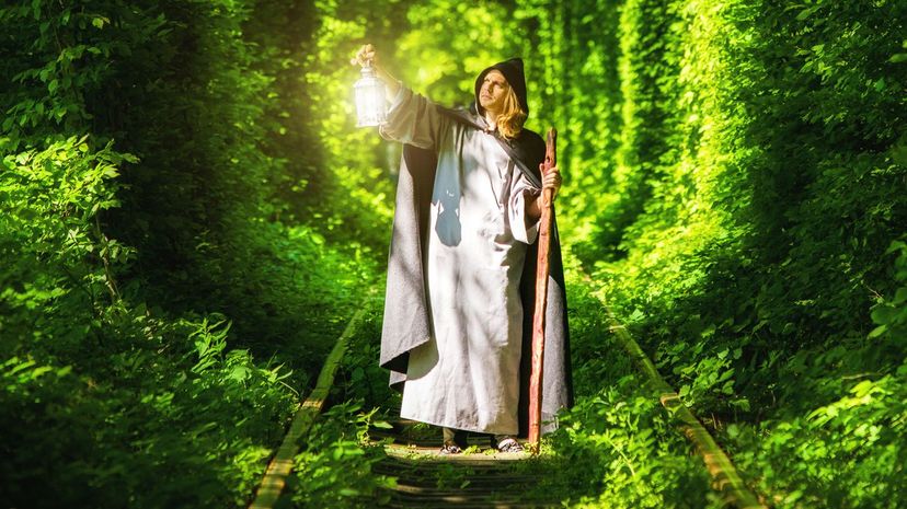 Wizard with a lantern in a tunnel of green forest