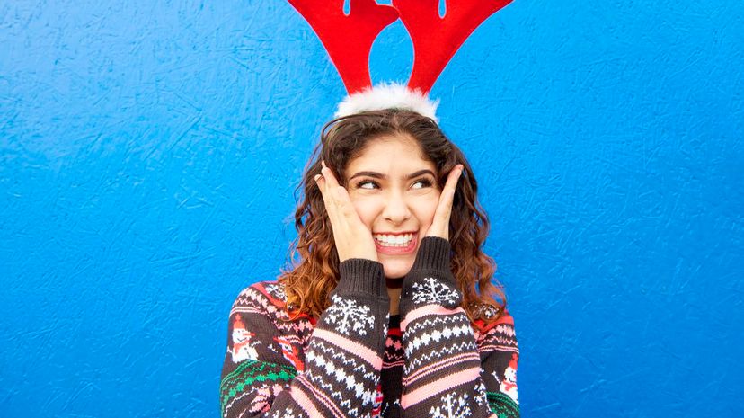 Smiling woman in Christmas jumper and crazy antlers